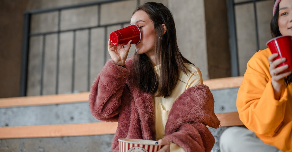 Why does microwave popcorn burn? - Woman in Brown Coat Drinking from Red Ceramic Mug Why does microwave popcorn burn? - Woman in Brown Coat Drinking from Red Ceramic Mug