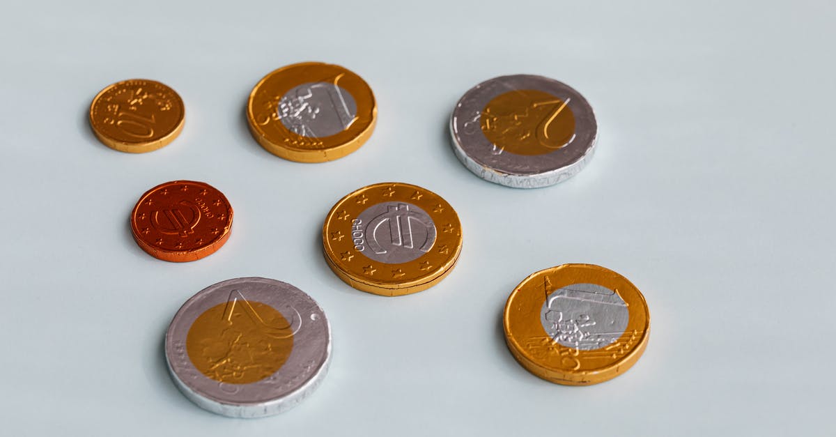 Why does milk and white chocolate have different tempering temperatures? - Chocolate coins on white surface Why does milk and white chocolate have different tempering temperatures? - Chocolate coins on white surface