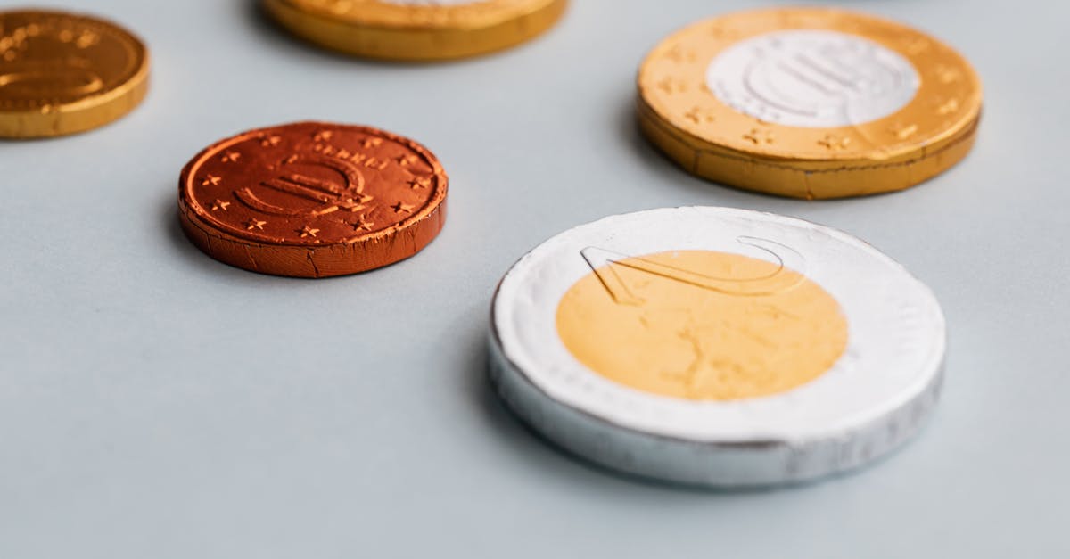Why does milk and white chocolate have different tempering temperatures? - Chocolate coins on white surface Why does milk and white chocolate have different tempering temperatures? - Chocolate coins on white surface