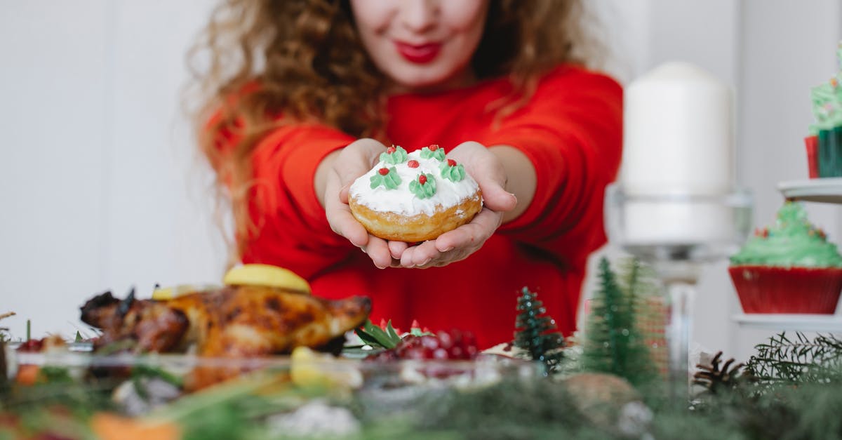 Why does my buttercream become runny overnight? - Crop woman showing tasty donut during New Year holiday indoors Why does my buttercream become runny overnight? - Crop woman showing tasty donut during New Year holiday indoors