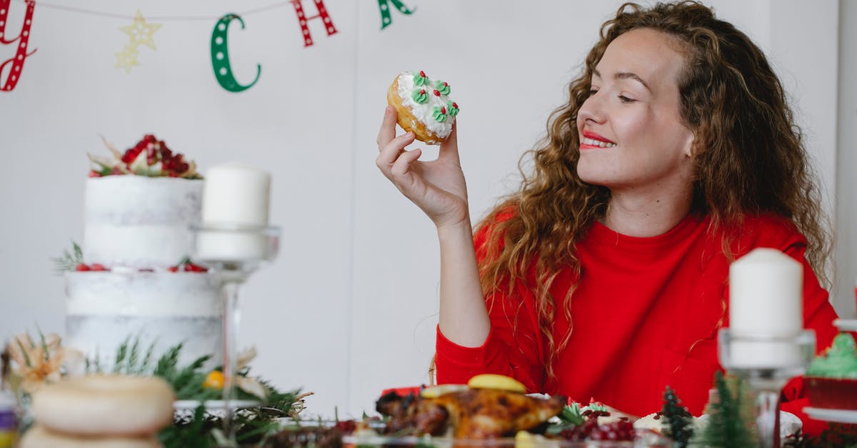 Why does my buttercream become runny overnight? - Content woman with delicious doughnut on Christmas day in house Why does my buttercream become runny overnight? - Content woman with delicious doughnut on Christmas day in house