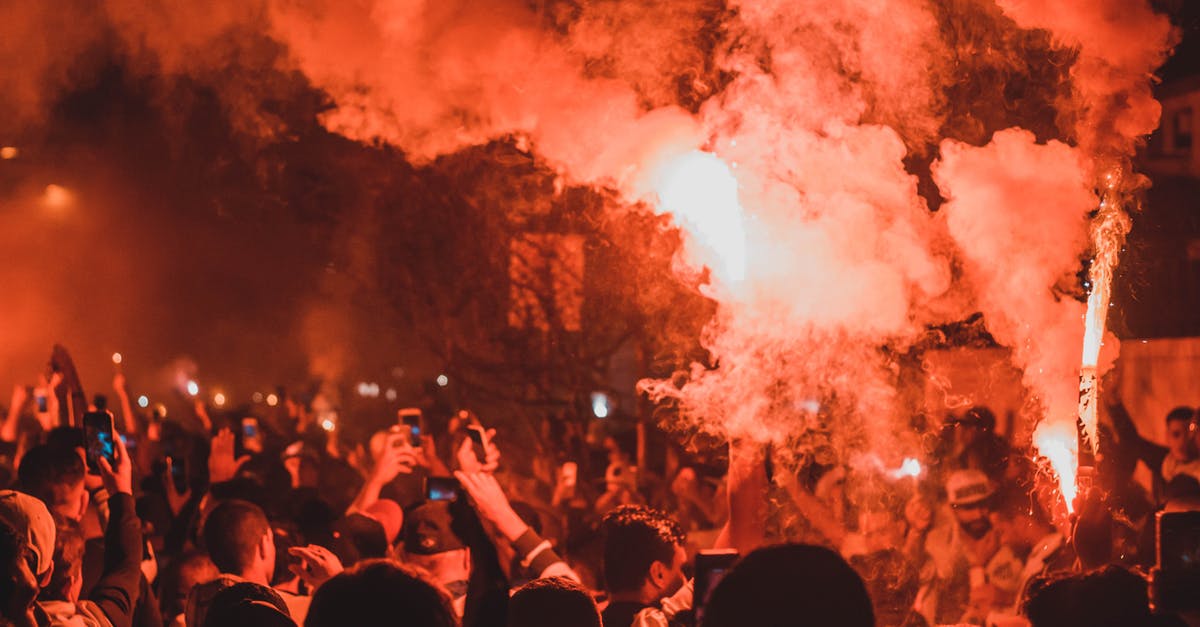 Why does my skillet burn even when using peanut oil? - Crowd of unrecognizable activists with burning torches standing on street among smoke during demonstrations at night