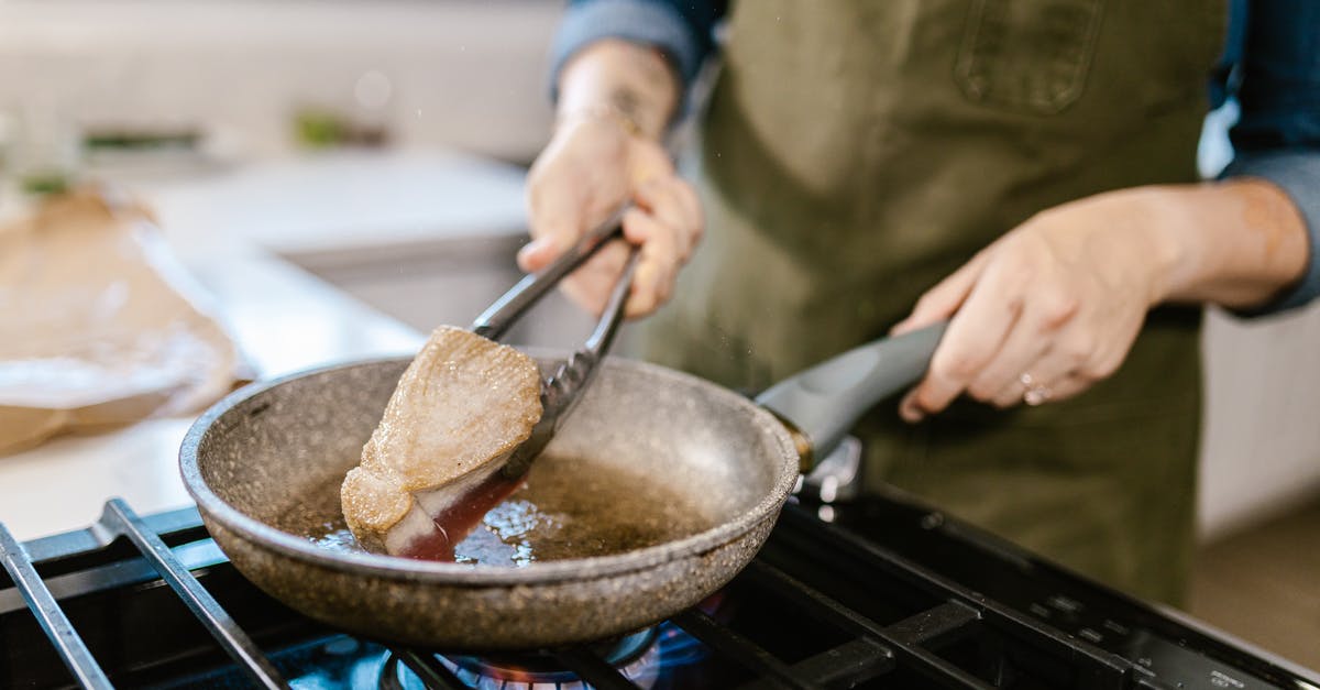 Why does my tuna Casserole turn sour? - Chunk of Tuna Fish Meat Turned on Frying Pan by Kitchen Pincers in Chefs Hand Why does my tuna Casserole turn sour? - Chunk of Tuna Fish Meat Turned on Frying Pan by Kitchen Pincers in Chefs Hand
