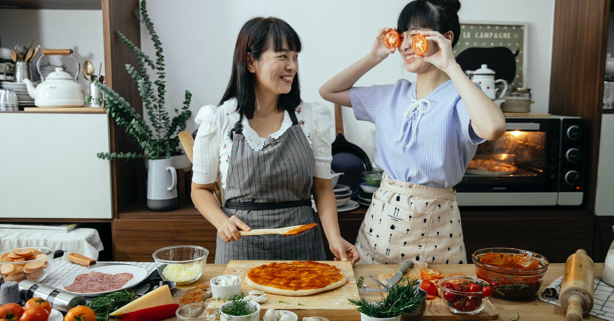 Why does Swiss Cheese have holes? - Positive women having fun cooking pizza Why does Swiss Cheese have holes? - Positive women having fun cooking pizza