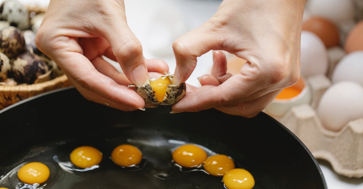 Why does this entire carton of eggs have 2 yolks each? - Crop woman breaking quail egg into pan Why does this entire carton of eggs have 2 yolks each? - Crop woman breaking quail egg into pan