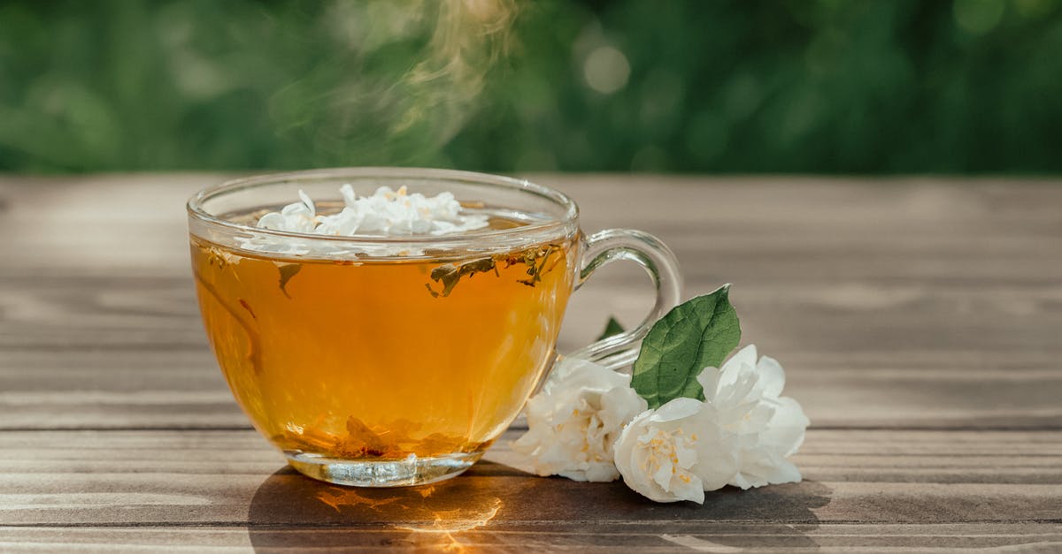 Why does this homemade herbal tea always boil over? - Glass cup of healthy herbal tea served on wooden table near fresh gentle Arabian jasmine flowers on sunny day on terrace Why does this homemade herbal tea always boil over? - Glass cup of healthy herbal tea served on wooden table near fresh gentle Arabian jasmine flowers on sunny day on terrace