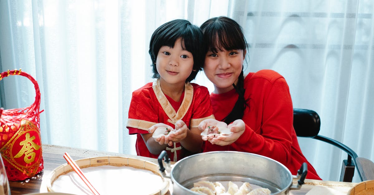 Why does waffle dough get dark? - Happy Asian teenage girl with dark hair cuddling with little brother and demonstrating traditional jiaozi dumplings during lunch preparation in kitchen Why does waffle dough get dark? - Happy Asian teenage girl with dark hair cuddling with little brother and demonstrating traditional jiaozi dumplings during lunch preparation in kitchen