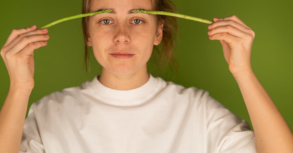 Why doesn't deep frying 'wet' the food? - Crop woman with fresh asparagus stems on green background Why doesn't deep frying 'wet' the food? - Crop woman with fresh asparagus stems on green background