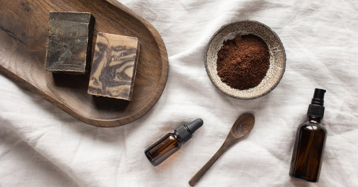 Why doesn't mayonnaise taste like pure oil? - Top view of coffee scrub in bowl composed with bottles of aromatic oil on white sheet