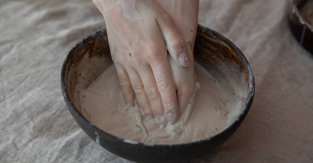 Why has my recently bought peanut butter such a liquid consistency? - From above of crop anonymous craftsperson mixing clay in round shaped bowl in workroom Why has my recently bought peanut butter such a liquid consistency? - From above of crop anonymous craftsperson mixing clay in round shaped bowl in workroom