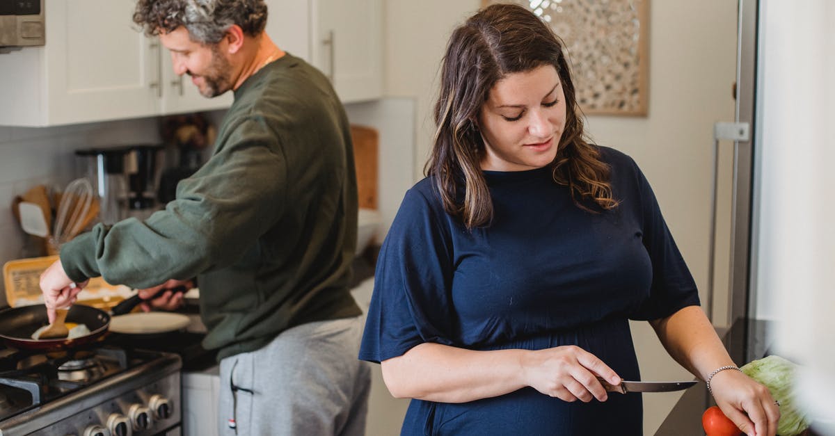 Why is lettuce rarely cooked? - Cheerful couple cooking dinner in kitchen Why is lettuce rarely cooked? - Cheerful couple cooking dinner in kitchen