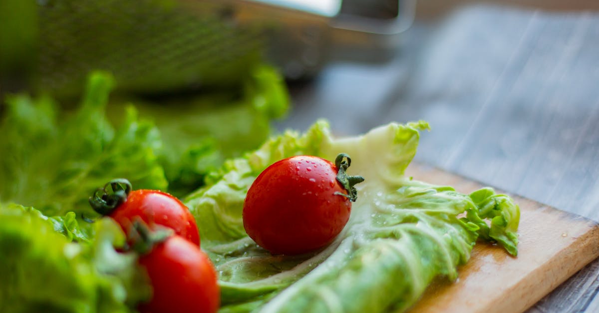 Why is my pickled red cabbage so pale? - Cutting board with fresh salad leaves and tomatoes placed on table near grater Why is my pickled red cabbage so pale? - Cutting board with fresh salad leaves and tomatoes placed on table near grater