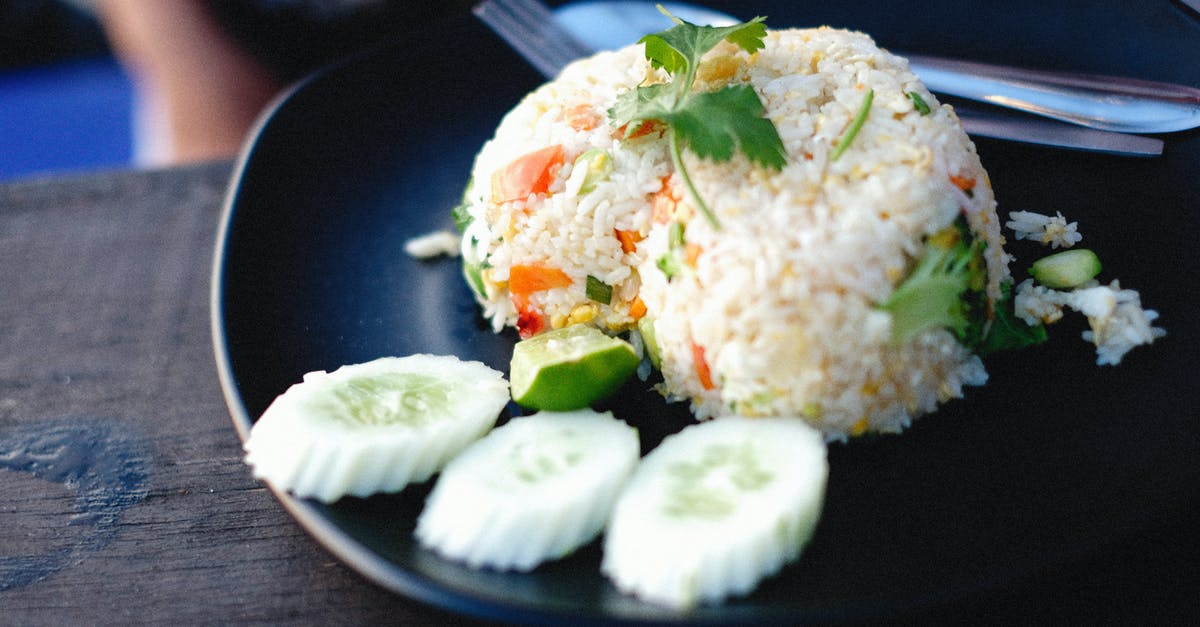 Why is rice parboiled? And how does parboiling change rice? - White Rice With Green Leaf Vegetable on Blue Ceramic Plate Why is rice parboiled? And how does parboiling change rice? - White Rice With Green Leaf Vegetable on Blue Ceramic Plate