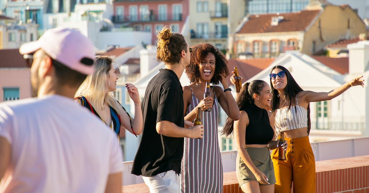 Why is the alcohol content in British beer so weak? - Joyful multiethnic friends laughing happily during party Why is the alcohol content in British beer so weak? - Joyful multiethnic friends laughing happily during party
