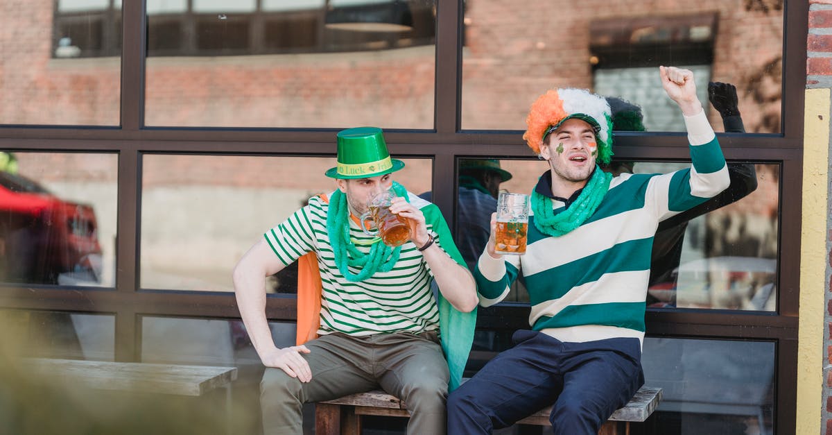 Why is the alcohol content in British beer so weak? - Joyful men drinking beer and yelling on street during national festival party Why is the alcohol content in British beer so weak? - Joyful men drinking beer and yelling on street during national festival party