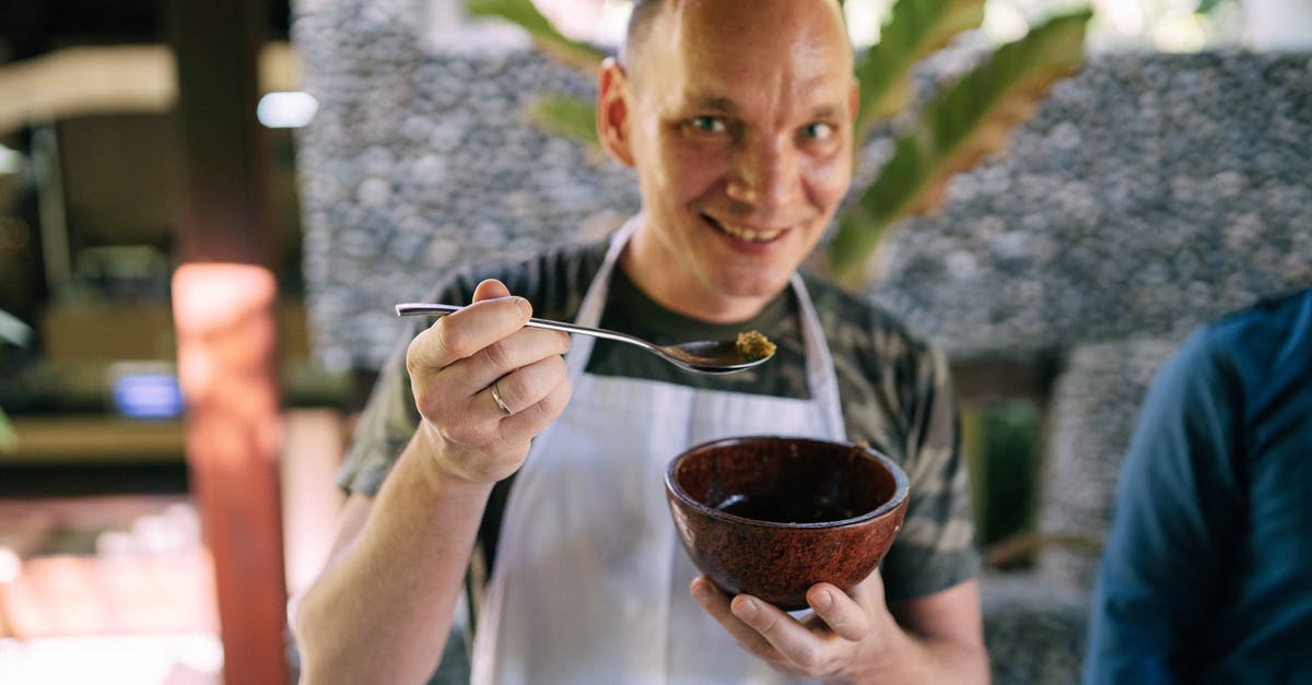 Why is this spoon bent sideways - Man in Blue and White Plaid Button Up Shirt Holding Silver Spoon Why is this spoon bent sideways - Man in Blue and White Plaid Button Up Shirt Holding Silver Spoon
