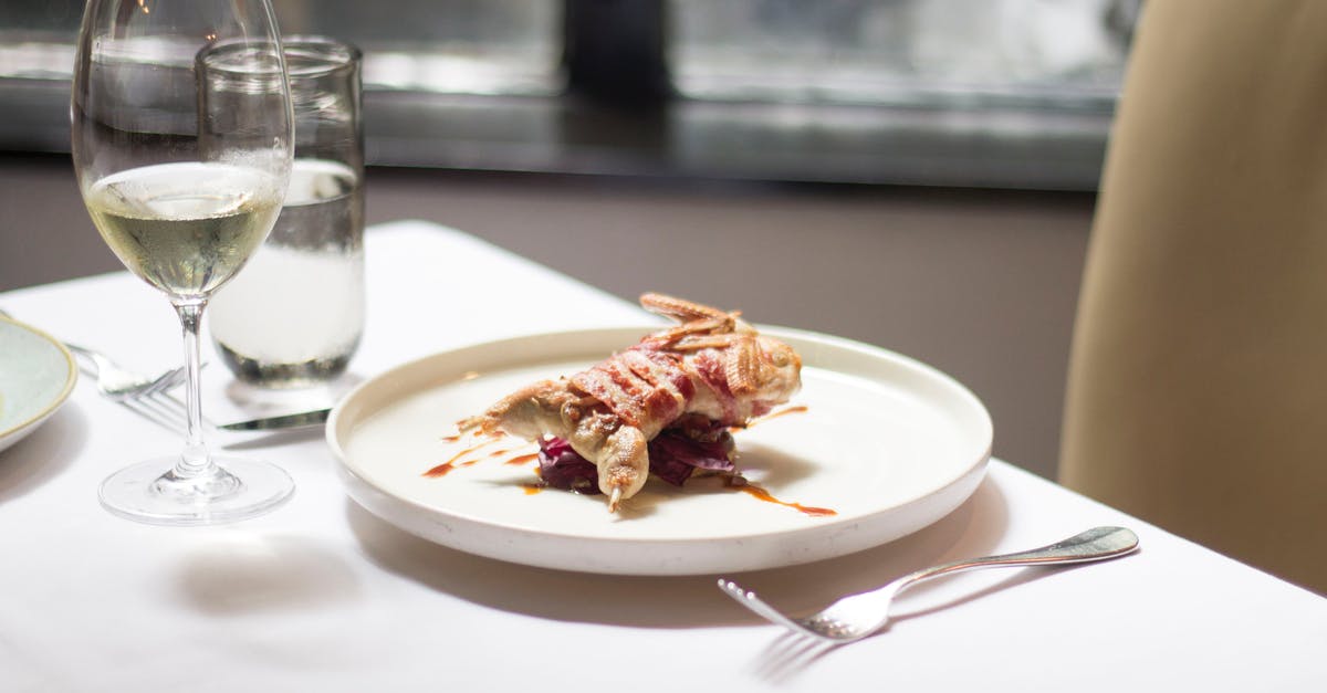 Why is wine not a common ingredient in (meat) stock? - Tablecloth on table with delicious plate with small roasted bird covered in bacon with sauce near glasses with wine and water near forks and knife in light restaurant near chair Why is wine not a common ingredient in (meat) stock? - Tablecloth on table with delicious plate with small roasted bird covered in bacon with sauce near glasses with wine and water near forks and knife in light restaurant near chair