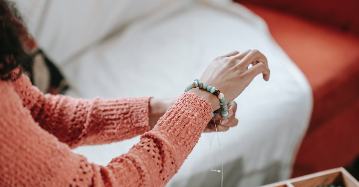 Why put a stone in the soup? - High angle of crop anonymous female designer tying decorative bracelet on wrist made of stones Why put a stone in the soup? - High angle of crop anonymous female designer tying decorative bracelet on wrist made of stones