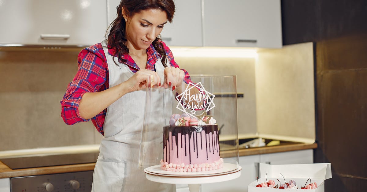 Why should I wrap a cake tin in newspaper? - Concentrated woman packing holiday cake Why should I wrap a cake tin in newspaper? - Concentrated woman packing holiday cake