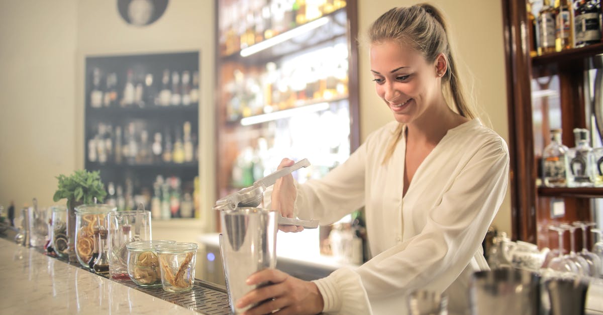 Why should we add alcohol to make extract - Smiling blonde in white blouse squeezing fresh juice into stainless shaker while preparing cocktail in bar Why should we add alcohol to make extract - Smiling blonde in white blouse squeezing fresh juice into stainless shaker while preparing cocktail in bar