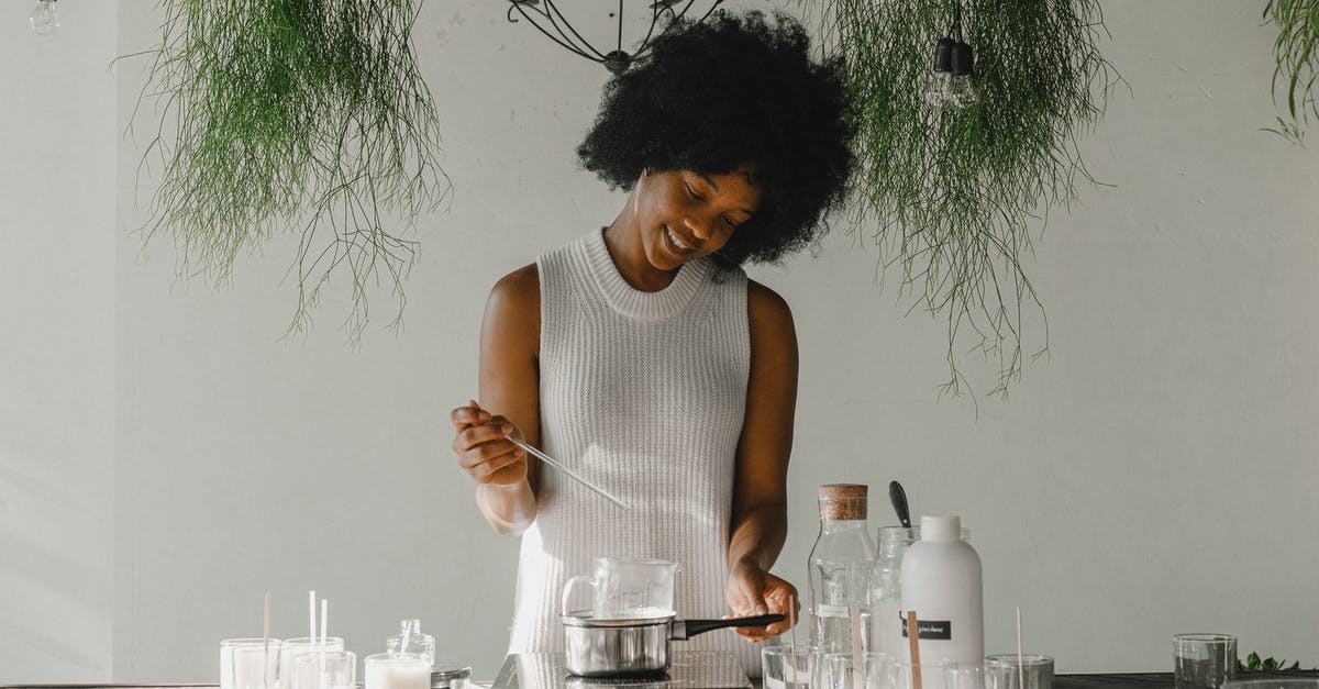 Why should we add alcohol to make extract - Smiling woman making candles in workshop Why should we add alcohol to make extract - Smiling woman making candles in workshop