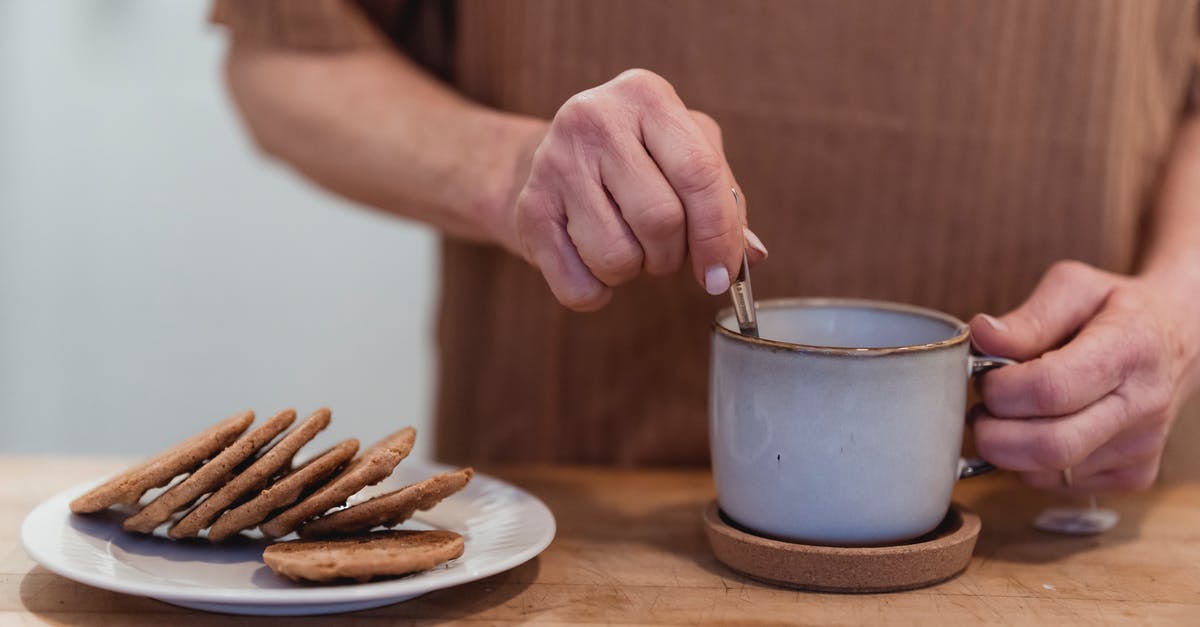 Why stir sourdough only with wooden spoons? - Faceless woman stirring tea at table with delicious cookies Why stir sourdough only with wooden spoons? - Faceless woman stirring tea at table with delicious cookies