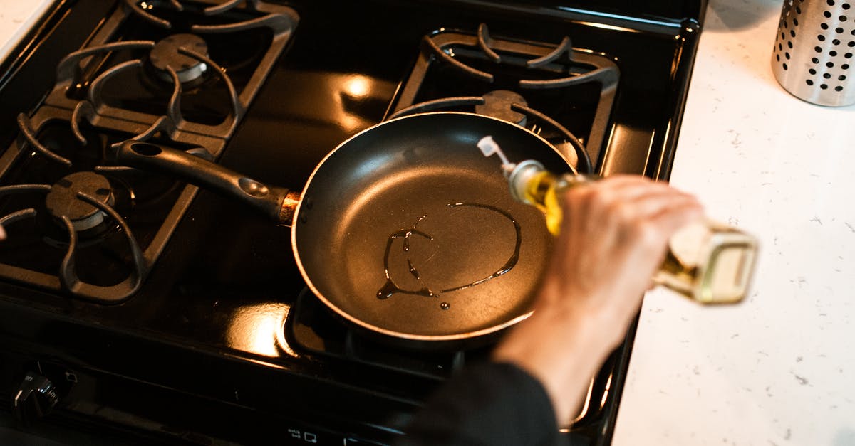 Why to store olive oil in opaque bottles? - Crop unrecognizable chef pouring oil in frying pan Why to store olive oil in opaque bottles? - Crop unrecognizable chef pouring oil in frying pan