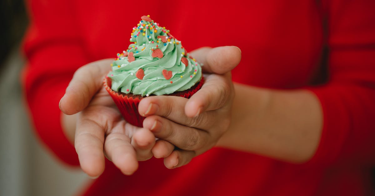 Why won't my whipped cream (with extras) stiffen up? - Crop anonymous lady in red dress demonstrating delicious cupcake decorated green whipped cream and colorful sprinkle on kitchen Why won't my whipped cream (with extras) stiffen up? - Crop anonymous lady in red dress demonstrating delicious cupcake decorated green whipped cream and colorful sprinkle on kitchen