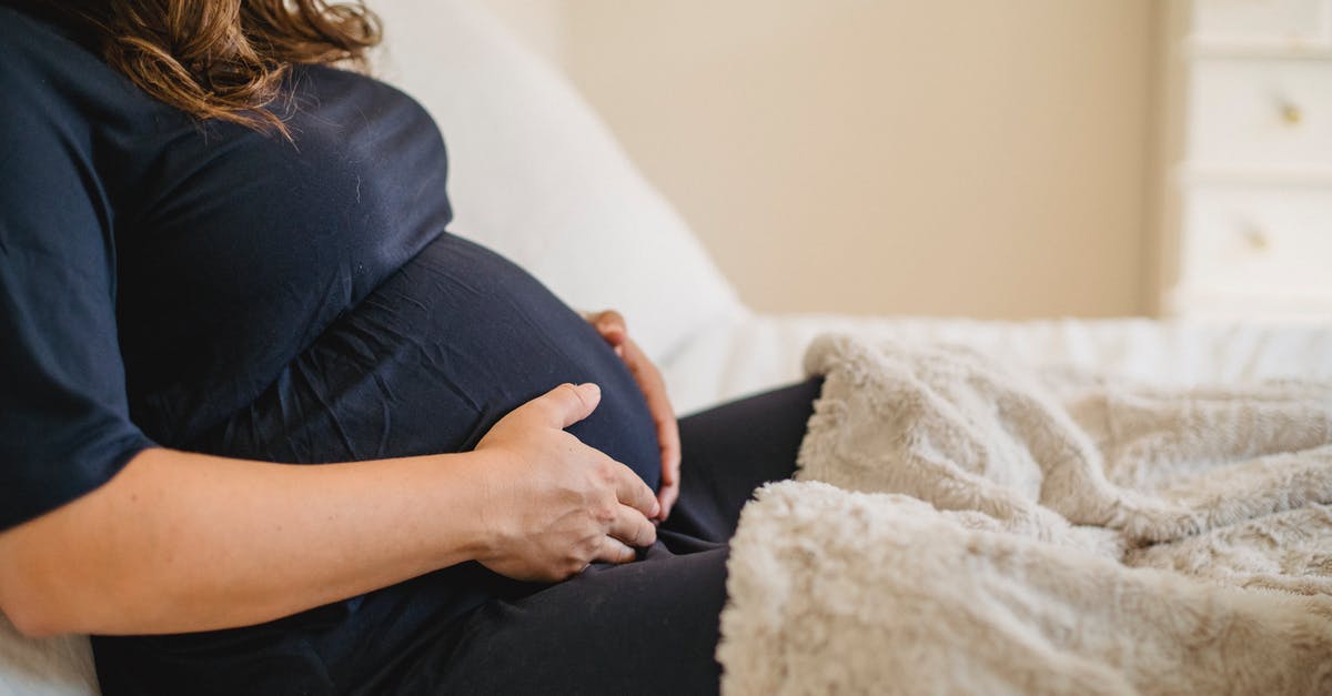 Why would a pregnant woman not be able to eat soft cheeses? [closed] - Crop expectant woman embracing tummy in bed at home