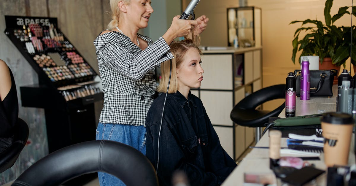 Why would boiling spinach decrease the iron content? - Side view of adult hairstylist straightening hair of client with iron in hairdressing salon