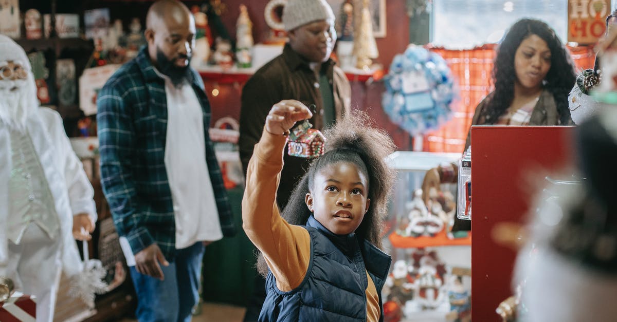Will apricot Jam glaze affect the shelf life of Christmas fruitcake? - Young African American parents with son and daughter looking for New Year gifts in souvenir shop