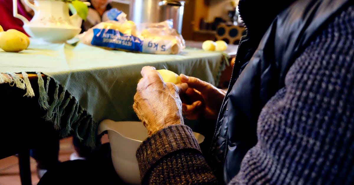Will peeling and slicing potatoes prevent them from sprouting further? - Person in Black and Purple Jacket in Front of Gray Table Mat Will peeling and slicing potatoes prevent them from sprouting further? - Person in Black and Purple Jacket in Front of Gray Table Mat