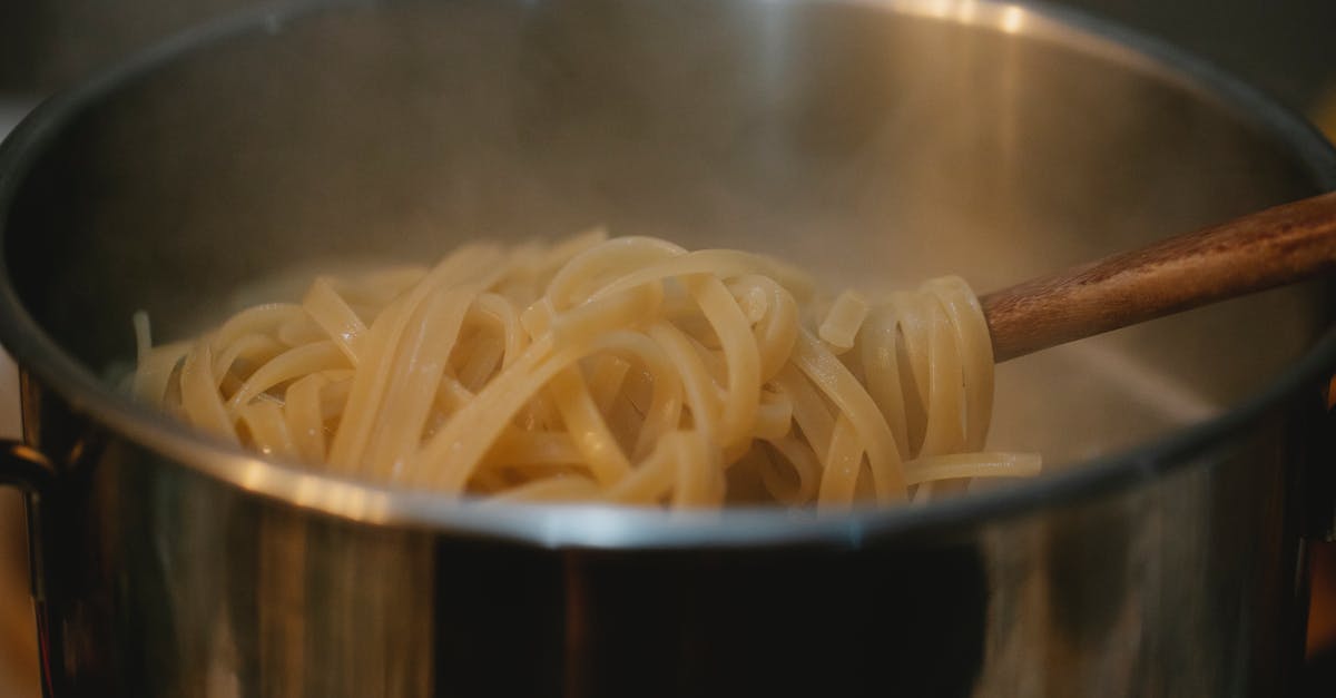 Will seasoning stainless steel increase heat transfer to pizza dough? - Metal pan with pasta in boiling water