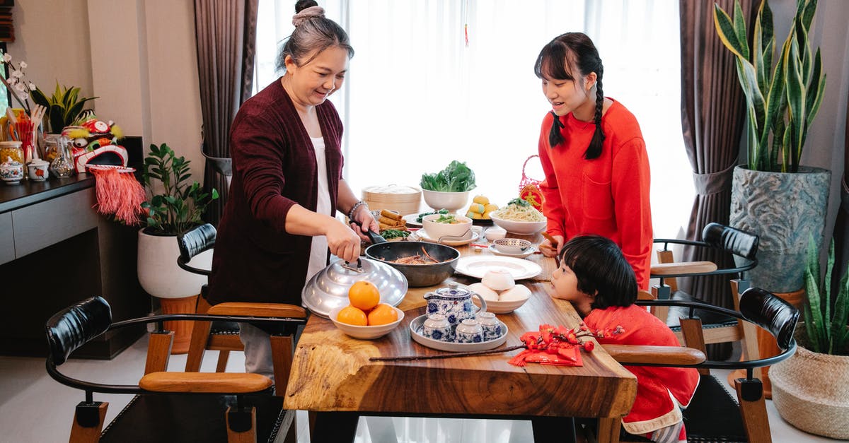 Wok patina; when to redo seasoning? - Smiling Asian grandmother with teen and boy serving delicious food Wok patina; when to redo seasoning? - Smiling Asian grandmother with teen and boy serving delicious food