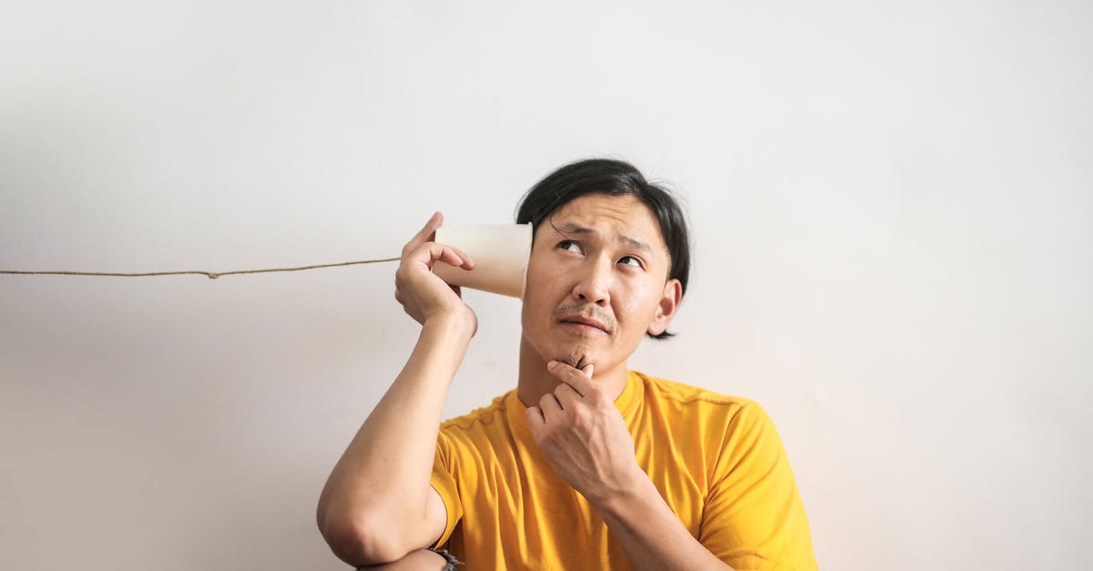 Yeast amounts unsure - Pensive ethnic man listening to answer in paper cup phone Yeast amounts unsure - Pensive ethnic man listening to answer in paper cup phone
